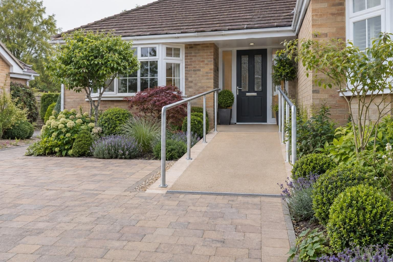 Gently sloping access ramp with handrails up to the front door of a bungalow Gently sloping access ramp with handrails up to the front door of a bungalow