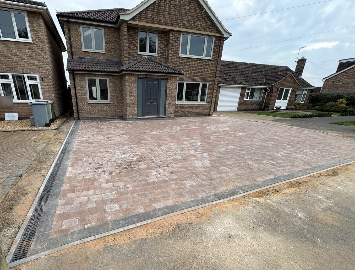Finished brindle block paved driveway with a charcoal double border in front of a brick house in Ryhall Finished brindle block paved driveway with a charcoal double border in front of a brick house in Ryhall