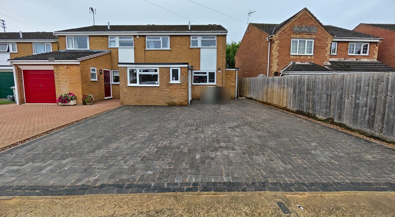 Full-width charcoal block paved driveway in front of a brick semi-detached house in Oakham Full-width charcoal block paved driveway in front of a brick semi-detached house in Oakham