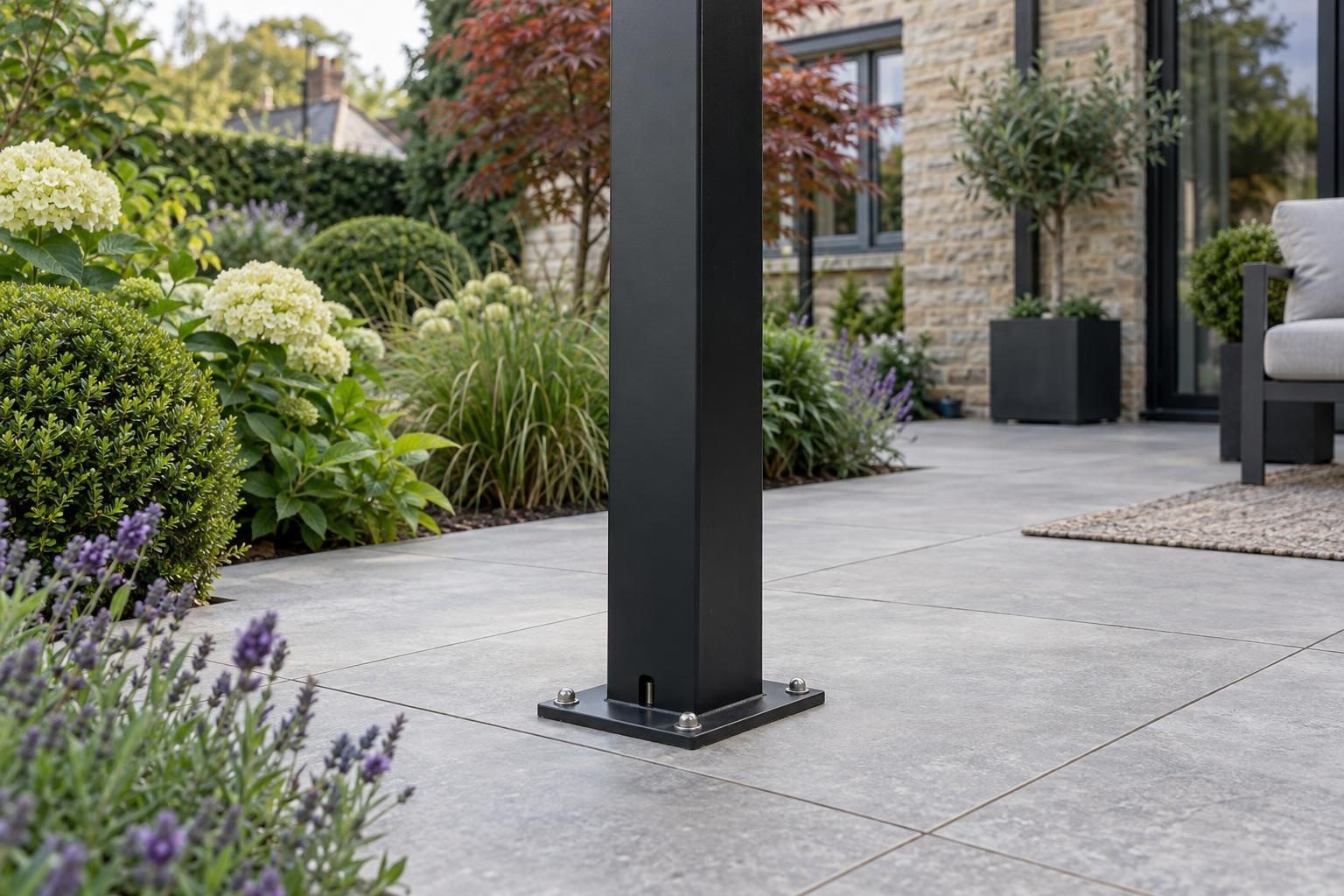 Pergola post base plate bolted to a porcelain patio Pergola post base plate bolted to a porcelain patio, with the drainage outlet at its foot
